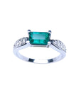 0.90 ct. East West emerald ring in 14k white gold with pave diamond accents.