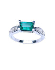 0.90 ct. East West emerald ring in 14k white gold with pave diamond accents.