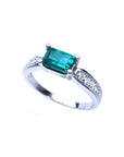 East West emerald ring with a vivid green rectangular emerald and diamond accents on a 14k white gold band.