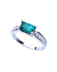 East West emerald ring with a vivid green rectangular emerald and diamond accents on a 14k white gold band.