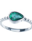 A teardrop emerald bezel set ring with accent diamonds in white gold displaying the topside view
