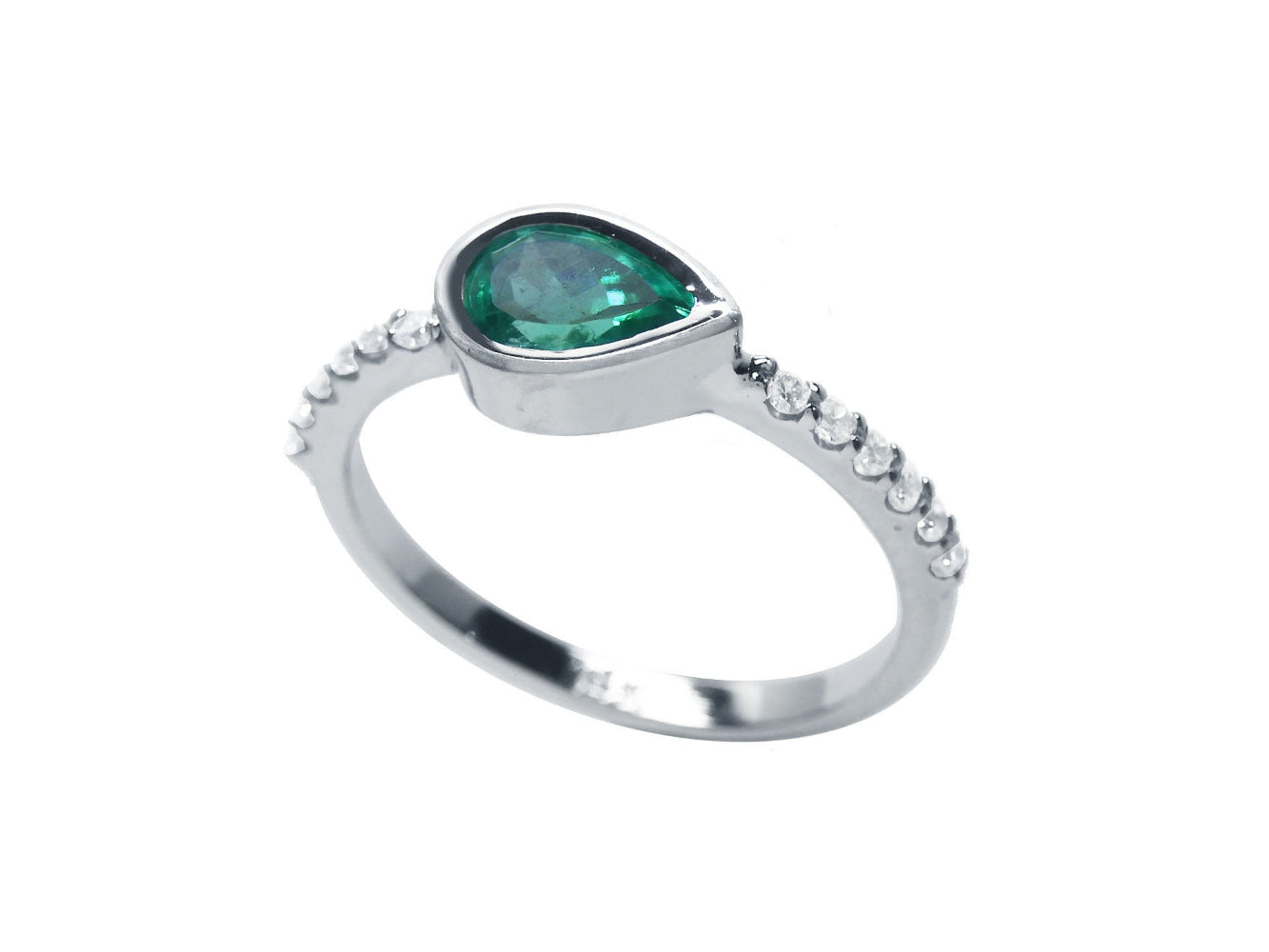 A partial side profile view of a teardrop emerald bezel set ring with accent diamonds in white gold.