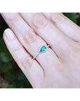 14K white gold ring with a bezel-set east-west teardrop emerald and diamond accents.