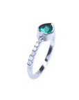 14K white gold ring with an east-west bezel-set teardrop emerald and prong-set accent diamonds.