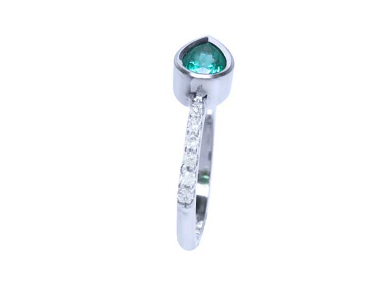 The perspective side view of a teardrop emerald bezel set ring with studded diamonds on the band.