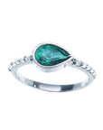 A teardrop colombian emerald bezel set ring with accent diamonds in 14k white gold for ladies.