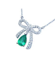 18K white gold bow-tie necklace with a pear-shaped deep green emerald.