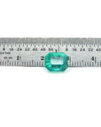 2.95 ct square natural Colombian emerald with bright medium green hue, shown on a ruler.