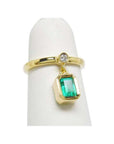 14K yellow gold dangle ring with a bezel-set emerald and small diamond accent.