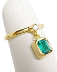 This is an emerald dangle ring representing May's birthstone jewelry displaying side profile.