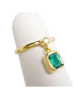 14K yellow gold ring with a bezel-set emerald dangle and a small round diamond accent.