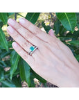 Hand modeling a 1.48 ct. emerald engagement ring and diamond wedding band set in 14K white gold.