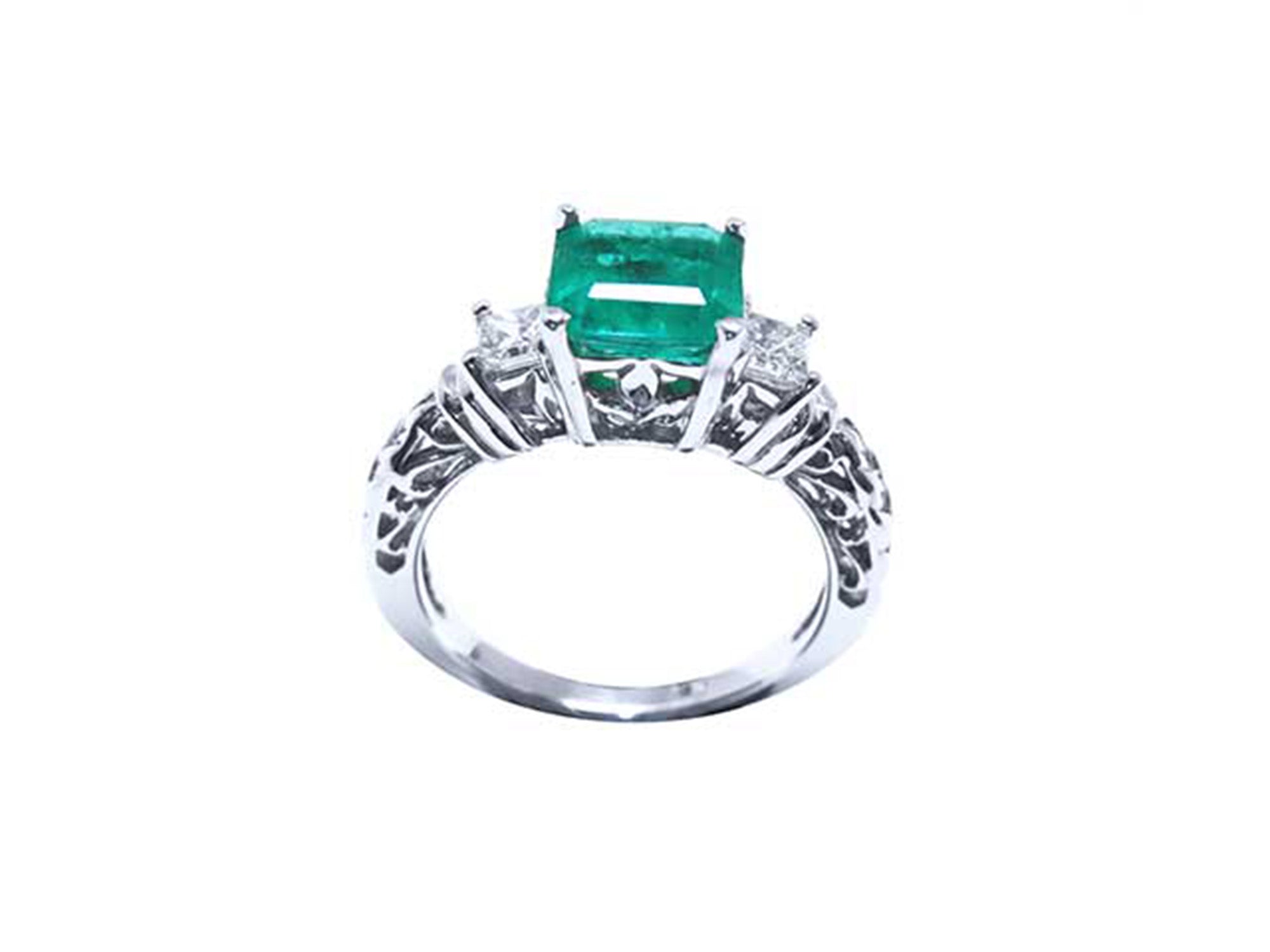 An emerald ring square emerald on top and side princess cut diamonds in whit gold.