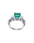 1.48 ct. emerald engagement ring with two side diamonds and intricate band in 14K white gold.