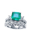 Top view of an emerald ring with a diamond matching band set in white gold.