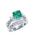 Emerald engagement ring with matching wedding band in white gold.