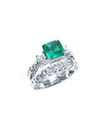 Emerald engagement ring with matching wedding band in white gold.