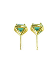 Pair of 14K yellow gold halo emerald stud earrings with vibrant green gemstones.