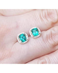1.55 carat emerald stud earrings with halo diamonds set in 14K yellow gold.
