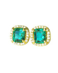 Pair of emerald stud earrings with halo diamond in yellow gold on a front position top view.