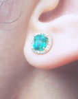 Close-up of an ear wearing a natural emerald stud earring.