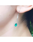 Emerald marquise earrings with deep bluish-green gems in a double marquise 14K white gold frame.