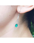 Emerald marquise earrings with deep bluish-green gems in a double marquise 14K white gold frame.