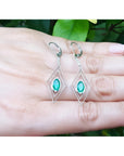 Deep bluish-green emerald marquise earrings in 14K gold with diamond lever backs, dangling from double marquise frames.
