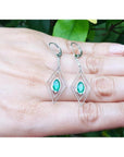 Deep bluish-green emerald marquise earrings in 14K gold with diamond lever backs, dangling from double marquise frames.