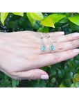 Emerald marquise earrings in 14K gold with deep bluish-green gems and diamond accents, dangling from lever backs.