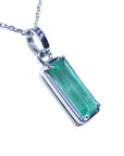 A natural colombian emerald pendant on a white gold chain displaying its topside and gallery profile.