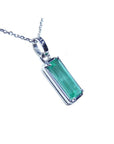 A natural colombian emerald pendant on a white gold chain displaying its topside and gallery profile.