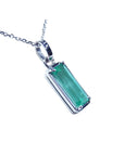 A natural colombian emerald pendant on a white gold chain displaying its topside and gallery profile.