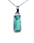 A solitaire emerald pendant on a white gold chain showing the topside view