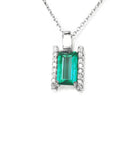 A natural emerald gemstone pendant with diamond accents on a topside view position.