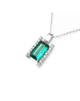 This emerald and baguette diamond pendant necklace is displaying the topside view.