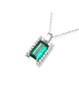 Baguette cut Colombian emerald and diamond pendant necklace in 14K white gold.