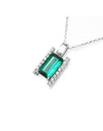 Baguette cut Colombian emerald and diamond pendant necklace in 14K white gold.