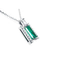 A white gold emerald baguette pendant with accent diamonds displaying the right-side gallery profile view.