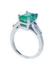 On a high-top position this emerald and baguette side diamond ring, displays its half side profile.