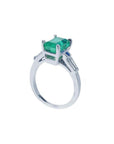 18K white gold ring with a rectangular deep bluish-green emerald and baguette side diamonds.