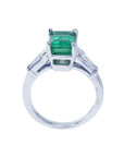 This three stone emerald and baguette side diamond ring white gold is on a lateral position, top and gallery profile visibles.
