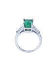 This three stone emerald and baguette side diamond ring white gold is on a lateral position, top and gallery profile visibles.