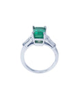 18K white gold ring with a vibrant green emerald and baguette side diamonds.