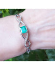 Emerald bangle bracelet for women enhanced by a entwines strip of near colorless natural diamonds 0.93 ct.