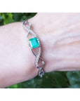 Emerald bangle bracelet for women enhanced by a entwines strip of near colorless natural diamonds 0.93 ct.