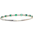 women's emerald bangle bracelet flexible made in 14k yellow gold and genuine Colombian emeralds.