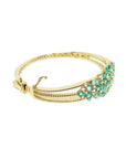 14K yellow gold bangle bracelet with round cut Colombian emeralds and diamonds in a floral design.