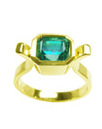 A topside view of a colombian emerald solitaire ring bezel set
