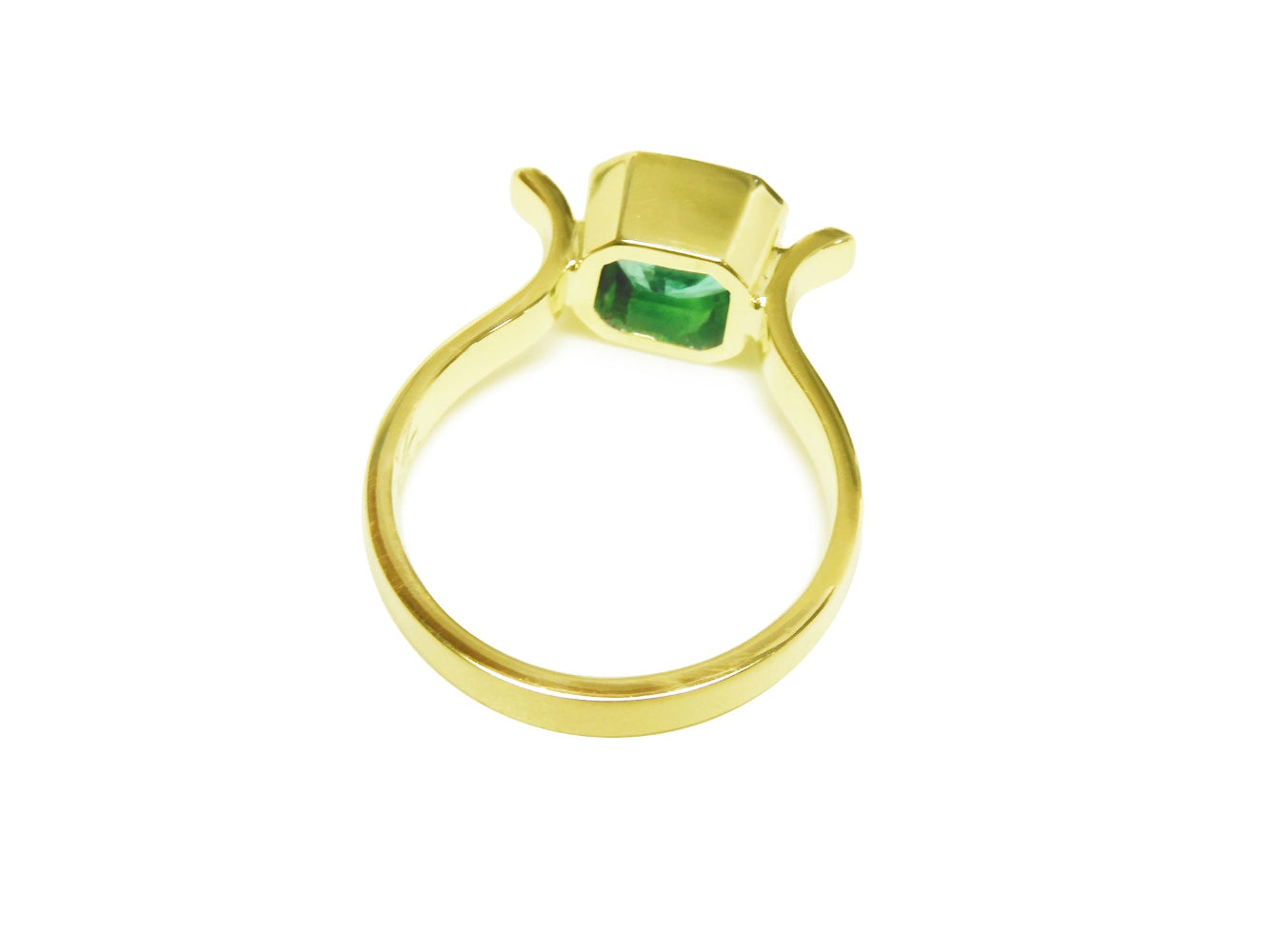 The underside view of a colombian emerald solitaire ring bezel set